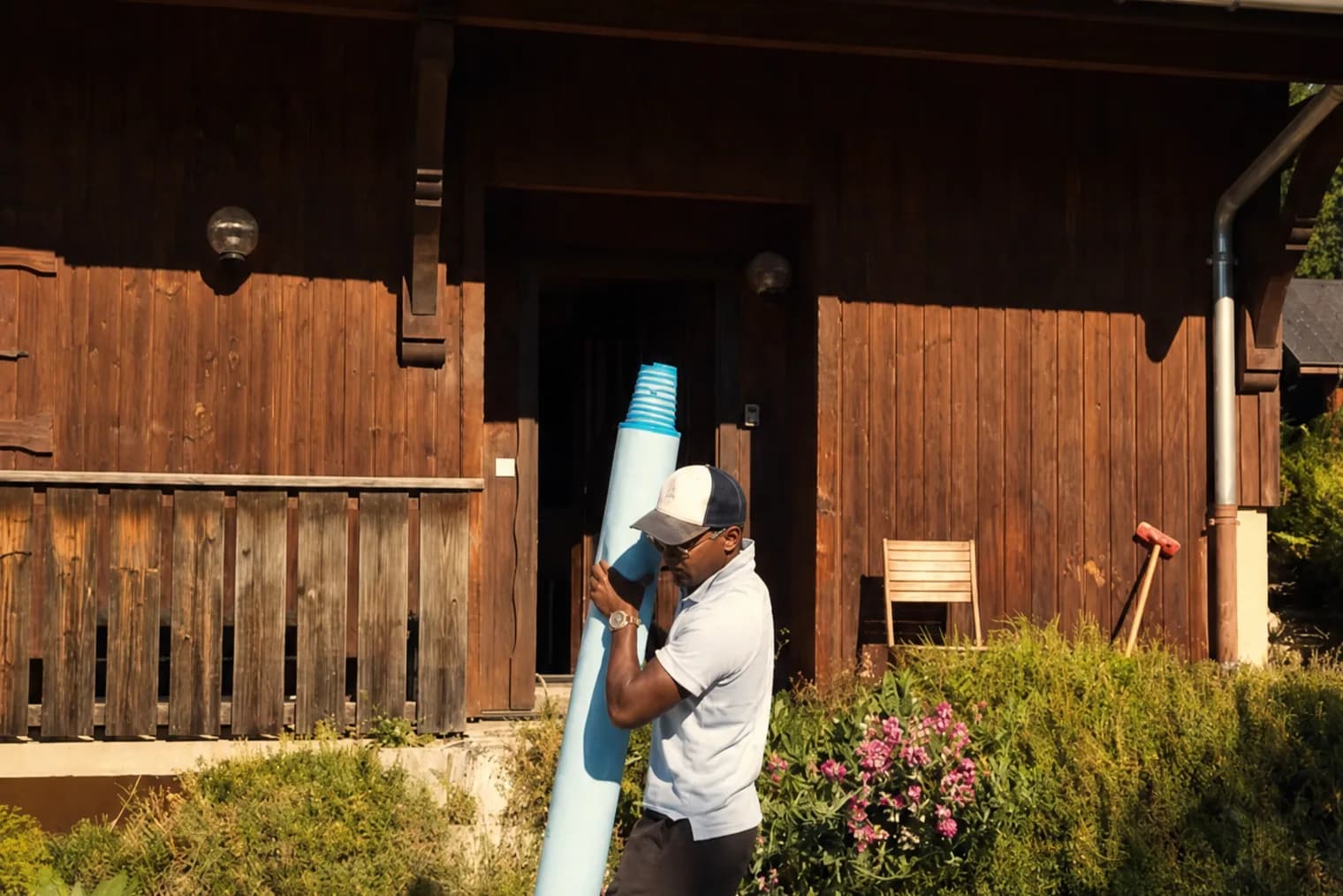 Bryan Elbaz porte un rouleau de membrane PVC armé sur un chantier de rénovation
