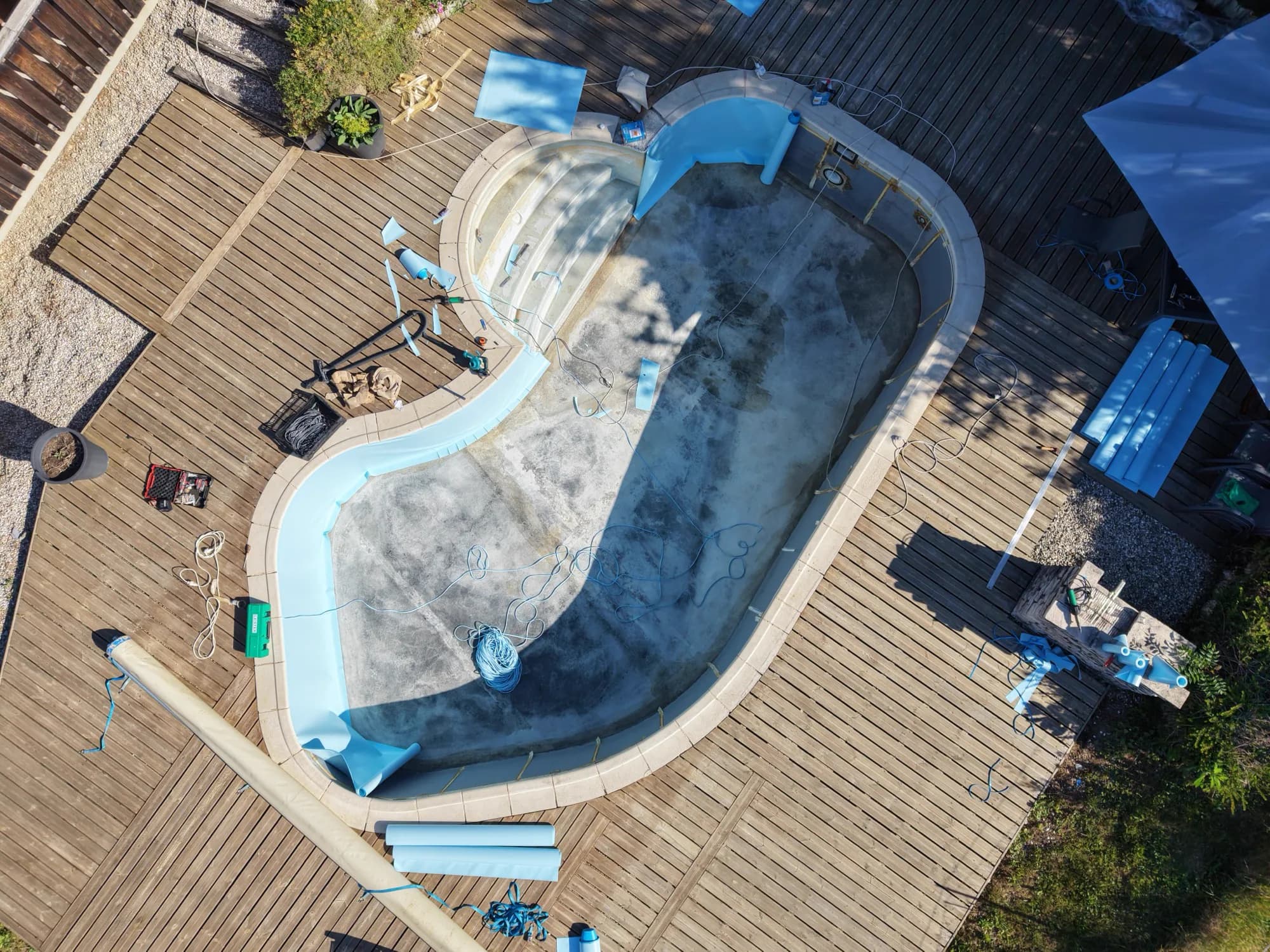 Rénovation en cours vue du ciel — l'équipe au travail sur un bassin forme libre